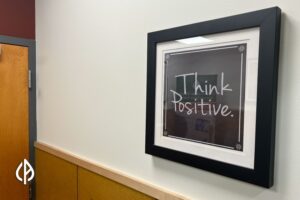 A framed photo reads "Think Positive" on a wall at Community Alliance.
