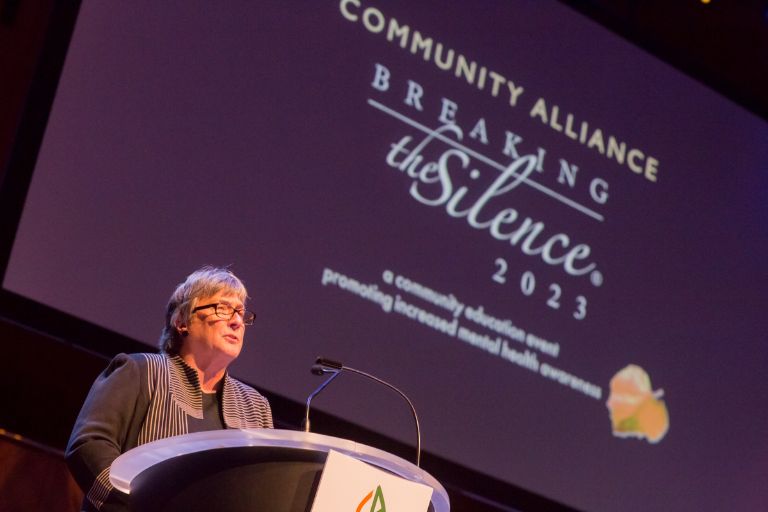 Community Alliance CEO Carole Boye speaks from the podium at Breaking the Silence 2023.