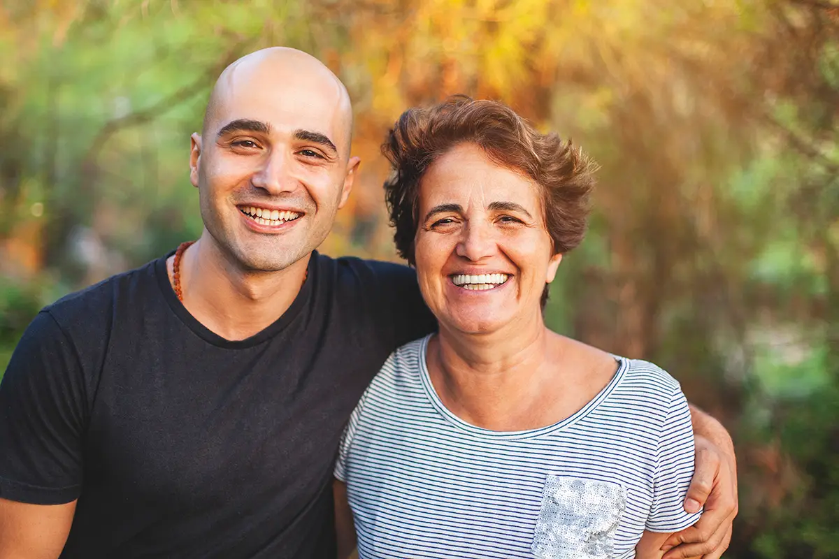 Mature mother and young son smiling at the park