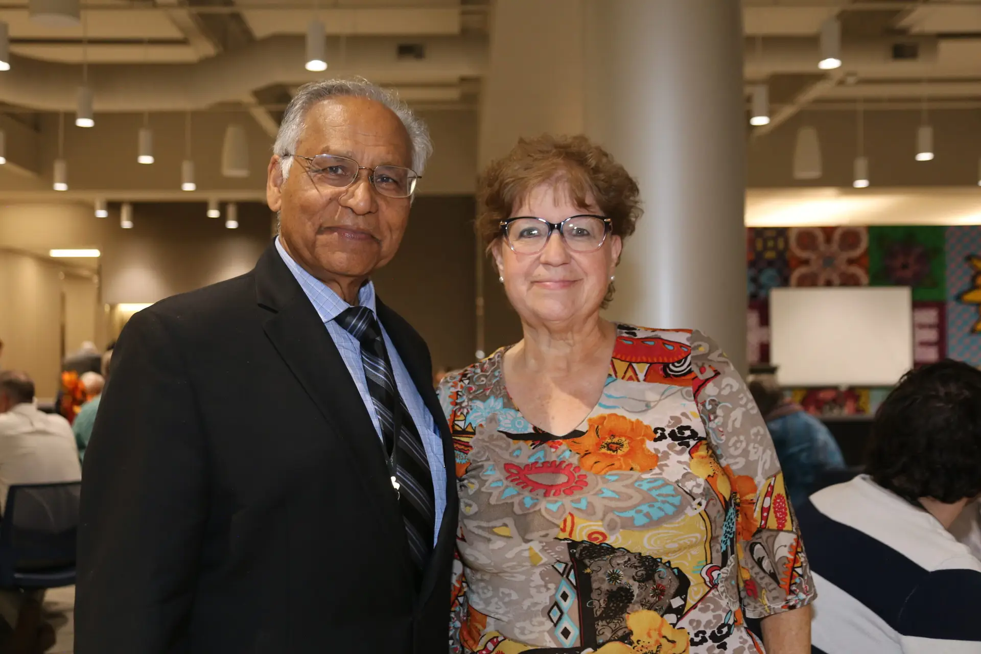 Dr. Jai smiling with attendee at a Family-to-Family Reunion event.